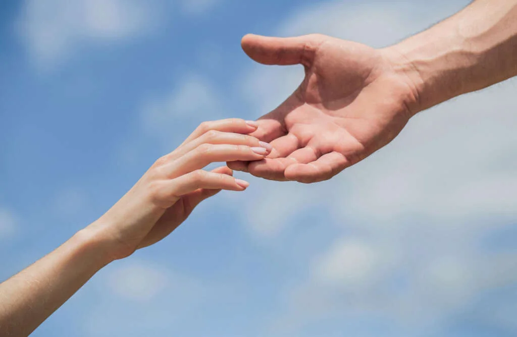 mains d'un homme et d'une femme se tendant l'une vers l'autre soutien compassion sauvetage offrir des mains secourables